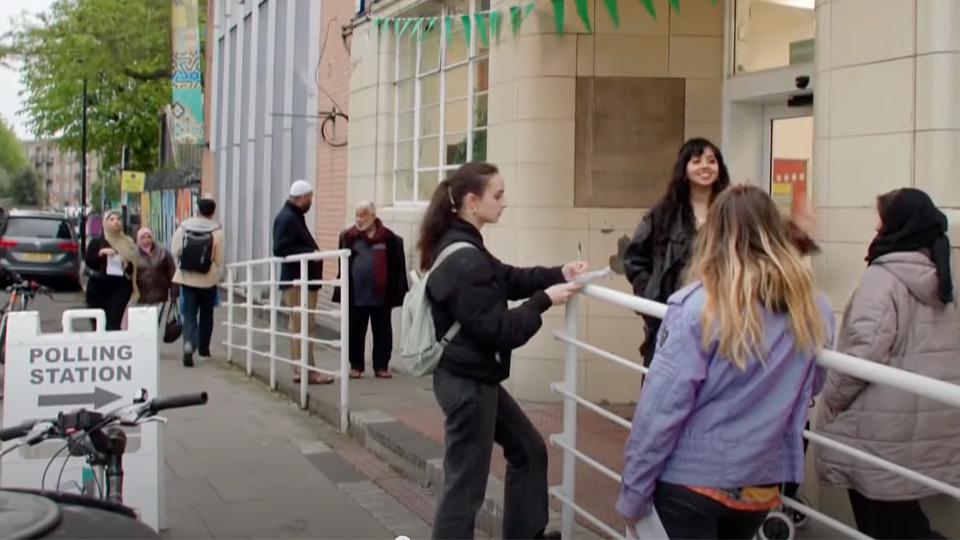 Two Goldsmiths students surveying voters exiting the polling station at the local elections