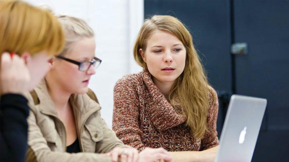 Students look at a laptop