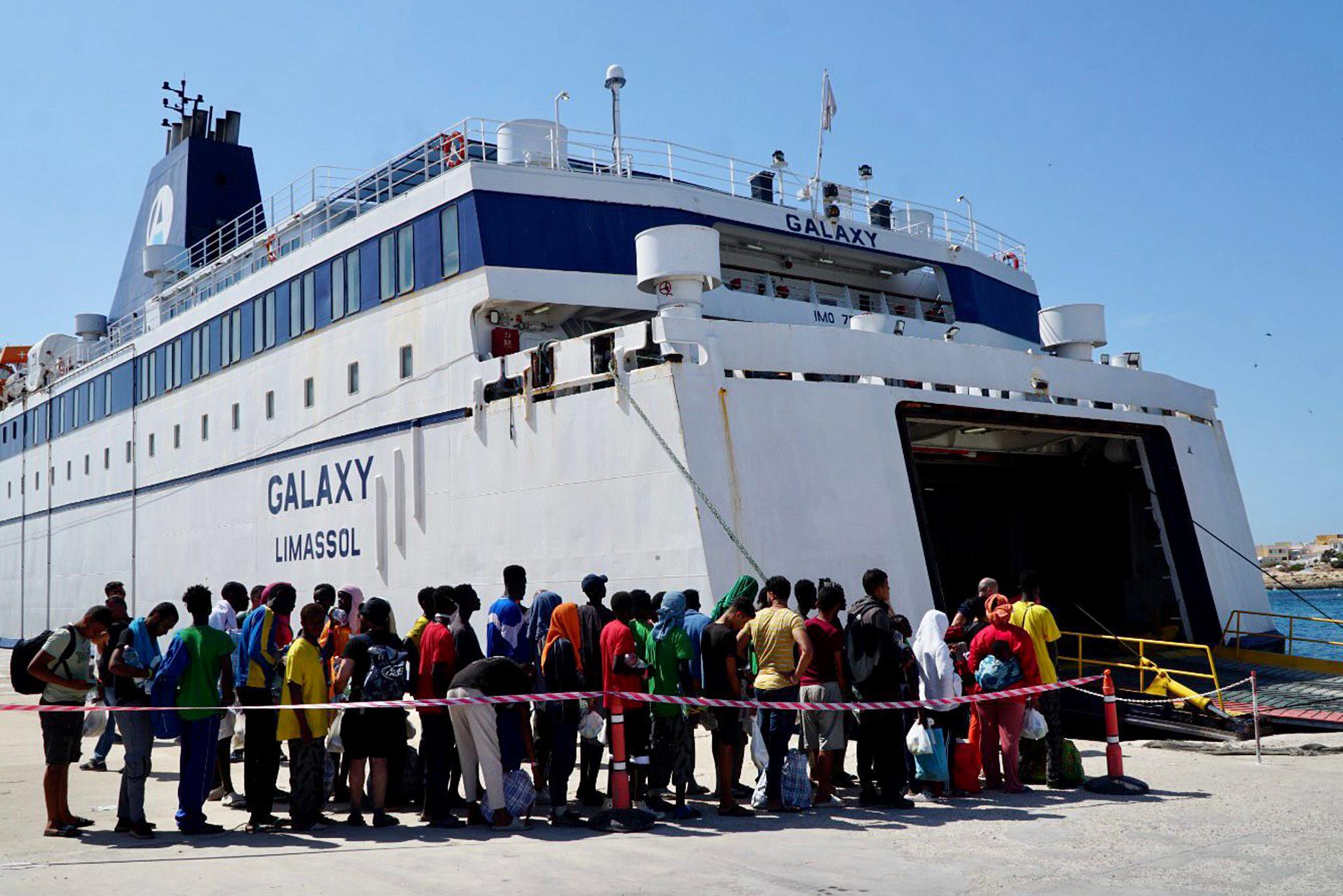 Migrants waiting to board a boat in Lampedusa, Italy