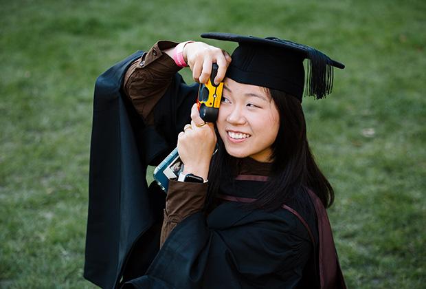 Graduate take a photo with a disposable camera