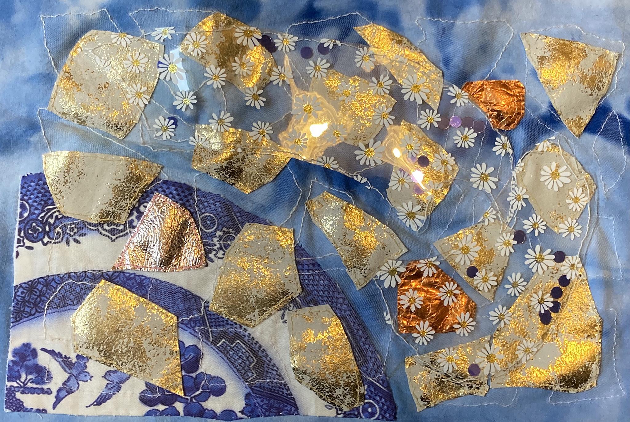  A blue piece of fabric with various fragments of gold material.